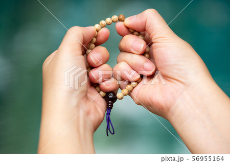 Woman's hands praying and holding a beads rosary in bokeh blue swimming pool background, Asian Body language feeling, Prayer buddhist, Religious concept Woman's hands praying and holding a beads rosary in bokeh blue swimming pool background, Asian Body language feeling, Prayer buddhist, Religious concept 56955164