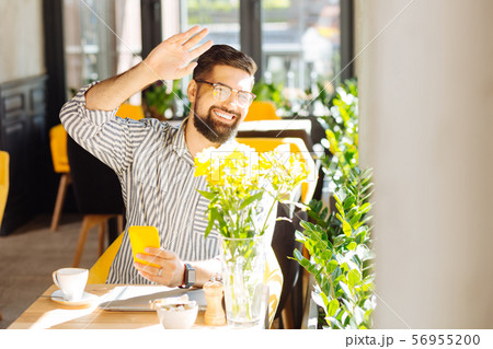 Joyful happy man holding his hand up Joyful happy man holding his hand up 56955200
