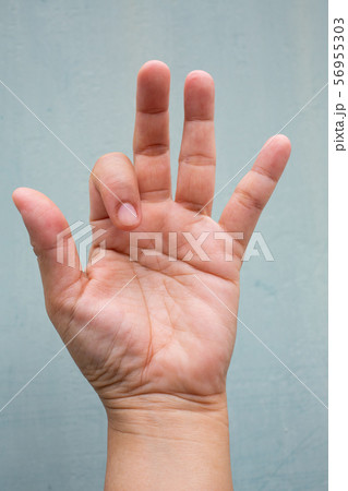 Trigger Finger lock on index finger of woman's front left hand, Suffering from pain, On Blue-grey colour background, Close up & Macro shot, Office syndrome, Health care concept Trigger Finger lock on index finger of woman's front left hand, Suffering from pain, On Blue-grey colour background, Close up & Macro shot, Office syndrome, Health care concept 56955303