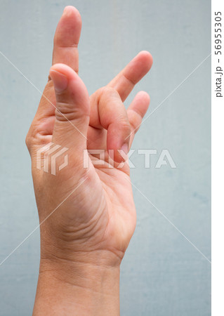 Trigger Finger lock on middle finger of woman's side left hand, Suffering from pain, On Blue-grey colour background, Close up & Macro shot, Office syndrome, Health care concept Trigger Finger lock on middle finger of woman's side left hand, Suffering from pain, On Blue-grey colour background, Close up & Macro shot, Office syndrome, Health care concept 56955305