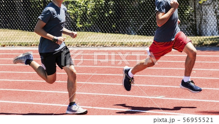 Two high school boys running fast on a track 56955521