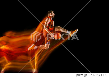Young caucasian basketball player against dark background in mixed light 56957178