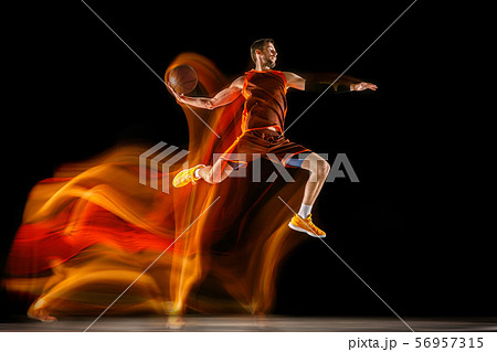 Young caucasian basketball player against dark background in mixed light 56957315
