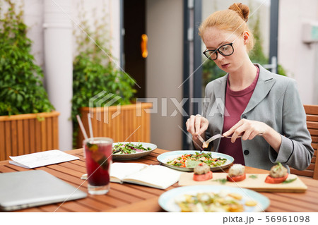 Businesswoman eating salad in cafe 56961098