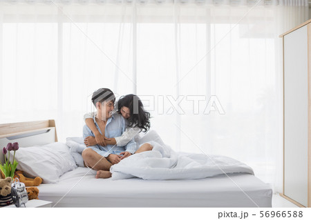 Couple sitting on bed, they hug each other by Couple sitting on bed, they hug each other by 56966588