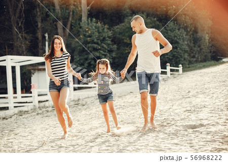 Family with daughter playing on a sand 56968222