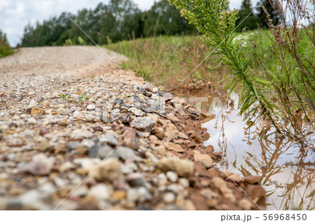 Flooded, muddy country road after rainfall and storm 56968450