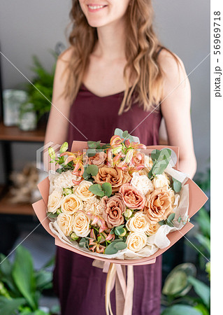 Beautiful bouquet of mixed flowers in woman hand. Floral shop concept . Handsome fresh bouquet Beautiful bouquet of mixed flowers in woman hand. Floral shop concept . Handsome fresh bouquet 56969718