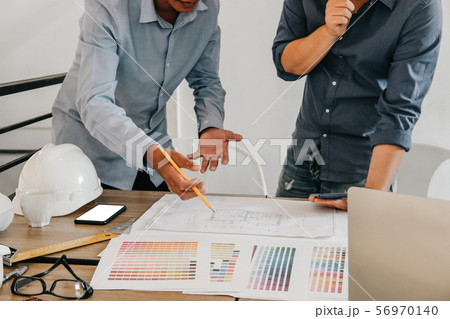 architect interior designer working with house drawing plan & color swatch architect interior designer working with house drawing plan & color swatch 56970140