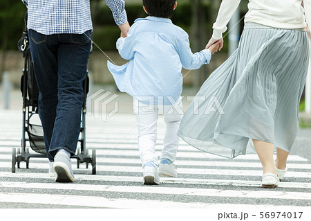 手を繋いで歩く家族3人の後姿 手を繋いで歩く家族3人の後姿 56974017