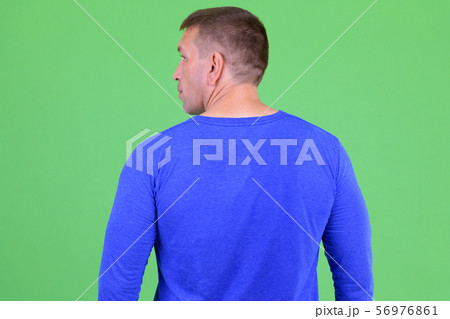 Rear view of macho mature man looking over shoulder 56976861