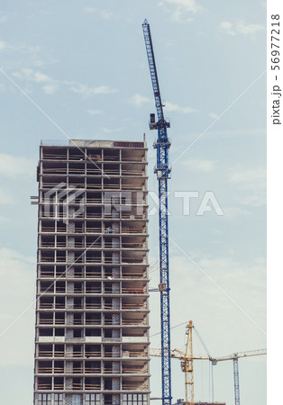 three building cranes at the background of a 56977218