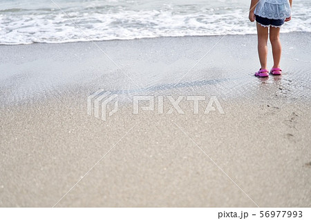 浜辺でたたずむ女の子の足元の写真素材 浜辺でたたずむ女の子の足元の写真素材
