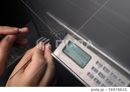 Close-up of Thief's hands breaking money safe 56978610