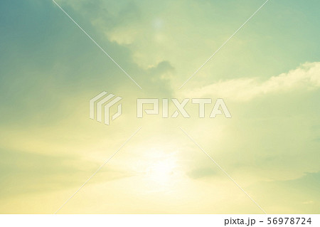 Blur nature background soft cloudy sky with bright light ray illumination glowing sunlight cloud sunset in pastel green yellow teal cyan blue 56978724