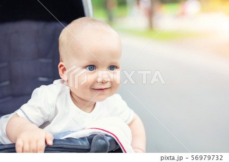 Cute caucasian blond curious baby boy sitting in stroller 56979732