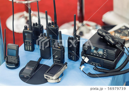 Many portable radio transceivers on table at 56979739