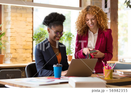 Interior designer smiling while working together on one project Interior designer smiling while working together on one project 56982355