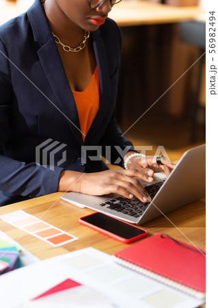 Interior designer wearing stylish necklace working on laptop 56982494