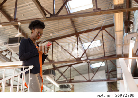 Dark-skinned designer texting her client while having questions 56982599
