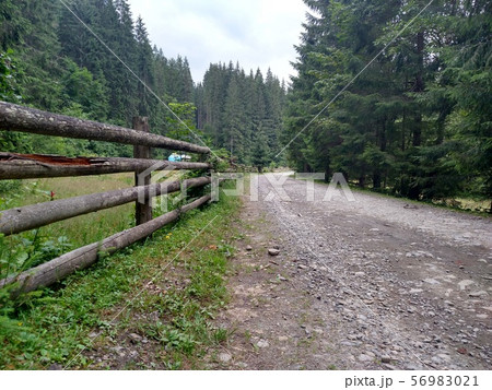 Dirt road near a wooden fence in the mountains Dirt road near a wooden fence in the mountains 56983021