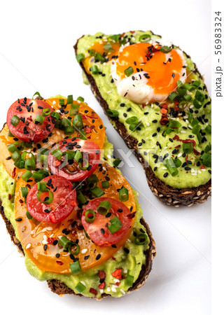 Sandwiches with avocado guacomole, egg and tomatoes, green leek and sesame seeds. Healthy breakfast Sandwiches with avocado guacomole, egg and tomatoes, green leek and sesame seeds. Healthy breakfast 56983324