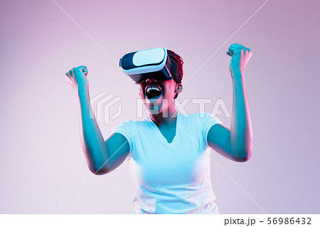 Young african-american woman's using VR-glasses in neon light 56986432