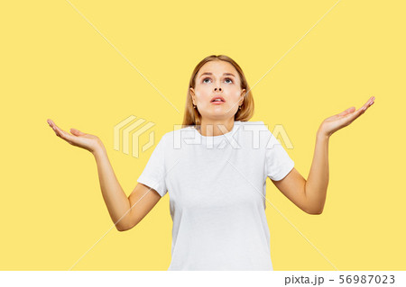 Caucasian young woman's half-length portrait on yellow background Caucasian young woman's half-length portrait on yellow background 56987023