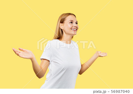 Caucasian young woman's half-length portrait on yellow background Caucasian young woman's half-length portrait on yellow background 56987040