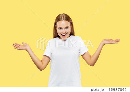 Caucasian young woman's half-length portrait on yellow background 56987042