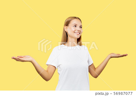 Caucasian young woman's half-length portrait on yellow background 56987077