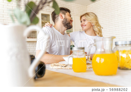 Happy couple is sitting on the kitchen Happy couple is sitting on the kitchen 56988202
