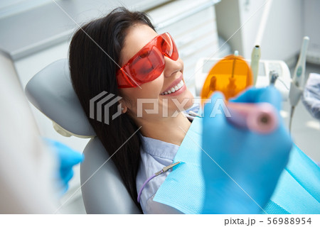 Dentist is treating teeth of young lady 56988954