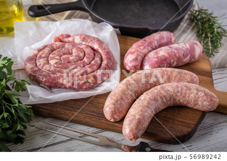uncooked sausage and ham on white wooden board 56989242