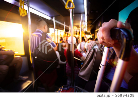 tourist bacpacker hold his luggage and cellphone on bus for transportation from airport terminal gate to airplane for transit and travel in order to relax on holiday with sunset time in Asia 56994309
