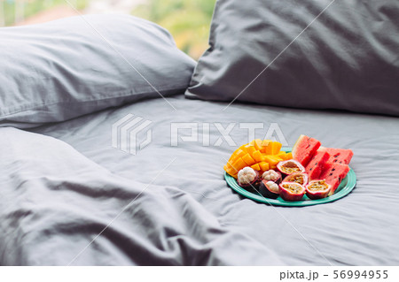 Plate with tropical fruit in grey bed, breakfast 56994955