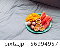 Plate with tropical fruit in grey bed, breakfast 56994957