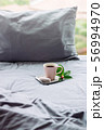 pink cup coffee, donut, flower on grey bed. pillow 56994970