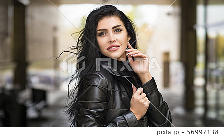 Urban woman walking in the city street during cold autumn day Urban woman walking in the city street during cold autumn day 56997138