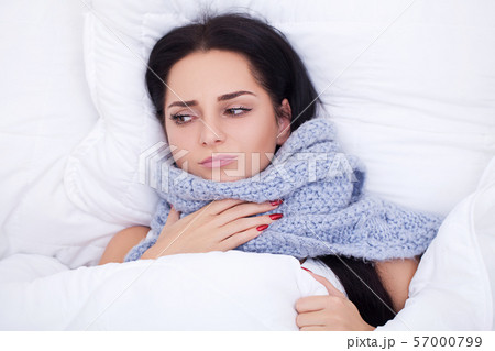 Sick young woman is coughing on the bed 57000799