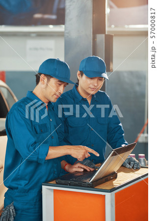 Car service workers reading e-mails Car service workers reading e-mails 57000817