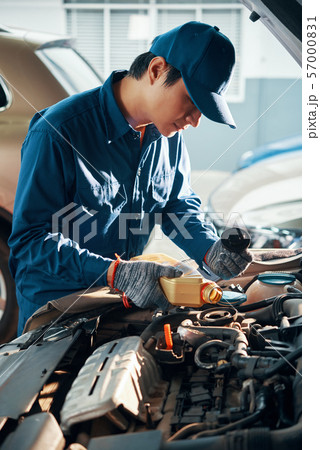 Service worker pouring engine oil 57000831