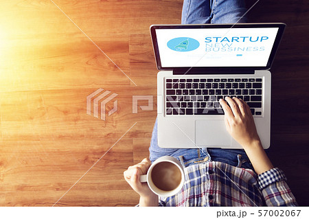 top view of people working on notebook laptop computer from home on wooden floor with startup business and rocket logo on screen, start up ideas business development top view of people working on notebook laptop computer from home on wooden floor with startup business and rocket logo on screen, start up ideas business development 57002067
