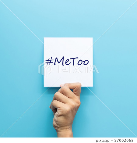 hashtag #MeToo on white paper in hand isolated on blue background. #MeToo is a campaign for movement against sexual harassment and sexual assault. hashtag #MeToo on white paper in hand isolated on blue background. #MeToo is a campaign for movement against sexual harassment and sexual assault. 57002068