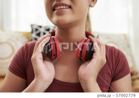 Woman with headphones around neck Woman with headphones around neck 57002779