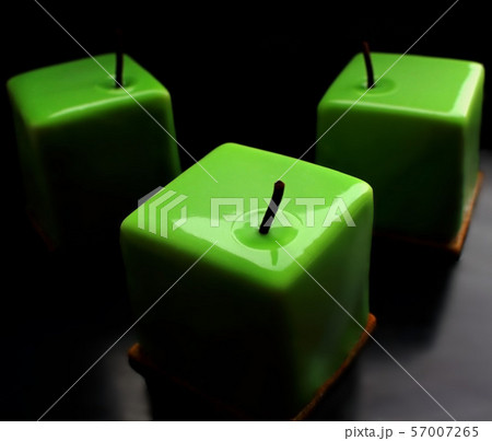 Green apple shiny glazed cube desserts on black background 57007265