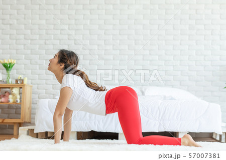 Asian woman practice yoga Cat pose to meditation in bedroom after wake up in the morning 57007381
