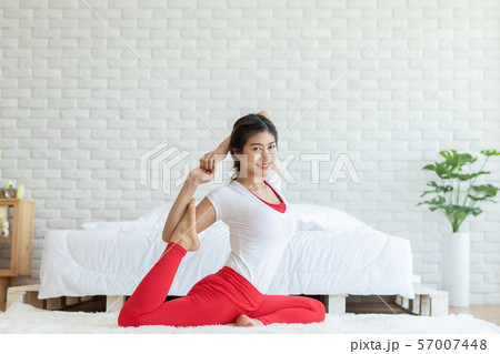 Attractive Asian woman practice yoga yoga mermaid pose to meditation in bedroom after wake up in the morning Feeling so comfortable and relax,Healthcare Concept 57007448