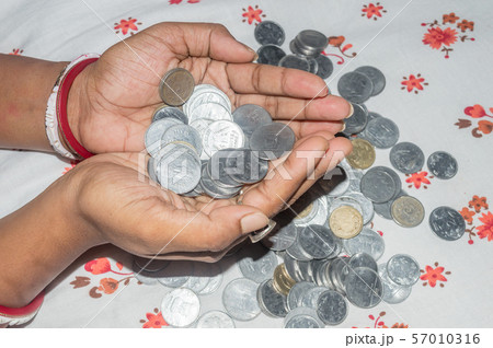 An indian poor housewife holding currency. Saving money for the future concept. An indian poor housewife holding currency. Saving money for the future concept. 57010316