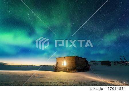 Aurora borealis over old small house with yellow 57014854